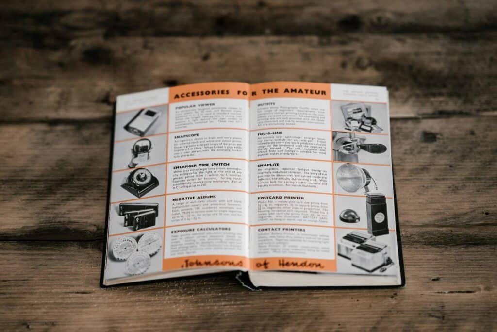 Open technical manual or product guide showing equipment accessories and descriptions on a wooden table