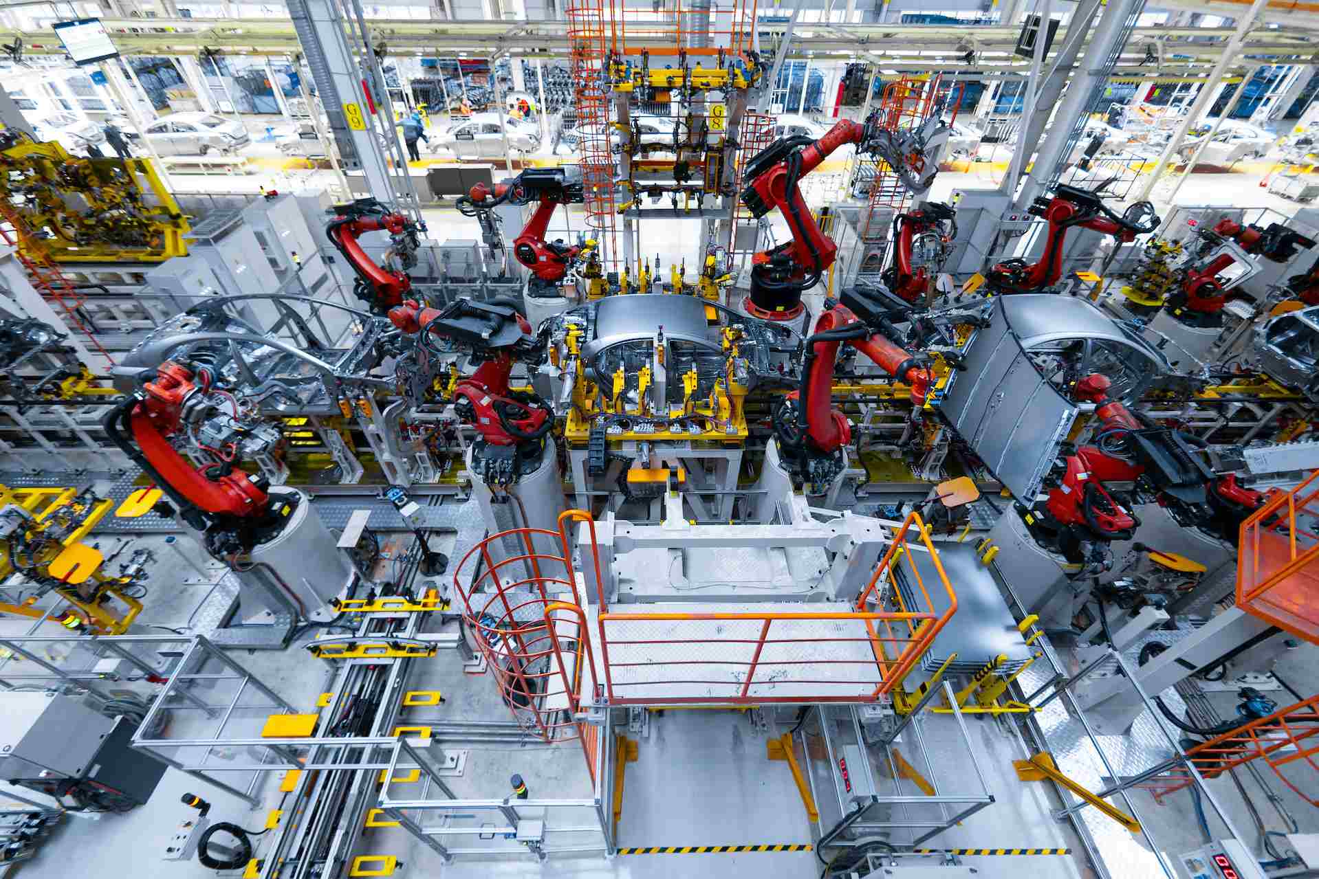 Automated manufacturing assembly line with robotic arms building vehicles in a modern factory