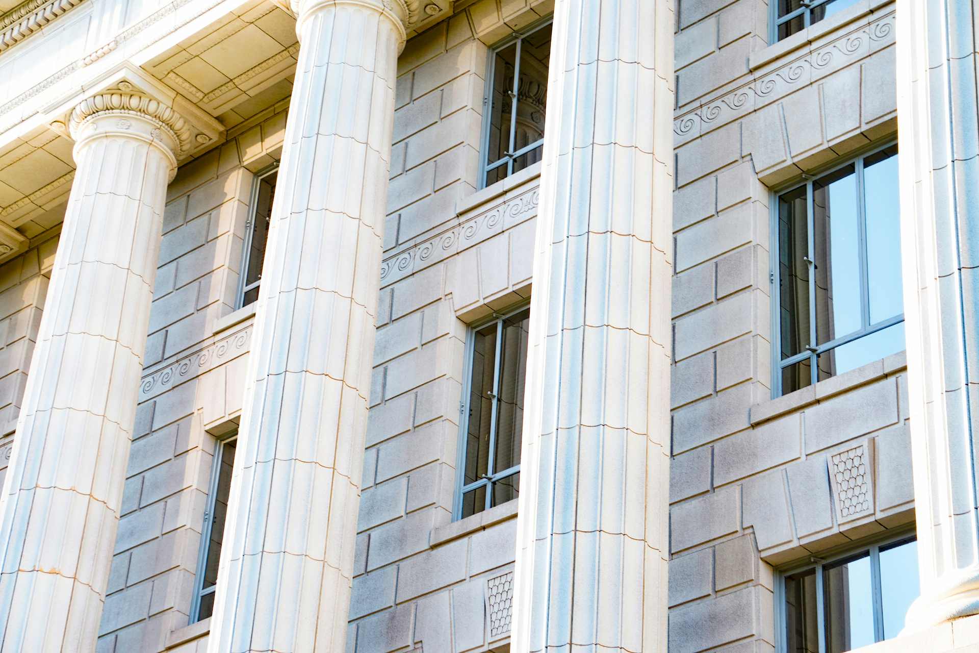 Exterior of a government building with large classical columns and stone facade.