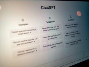 Close-up of the ChatGPT home screen displaying example prompts, capabilities, and limitations on a computer monitor.