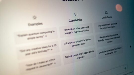 Close-up of the ChatGPT home screen displaying example prompts, capabilities, and limitations on a computer monitor.