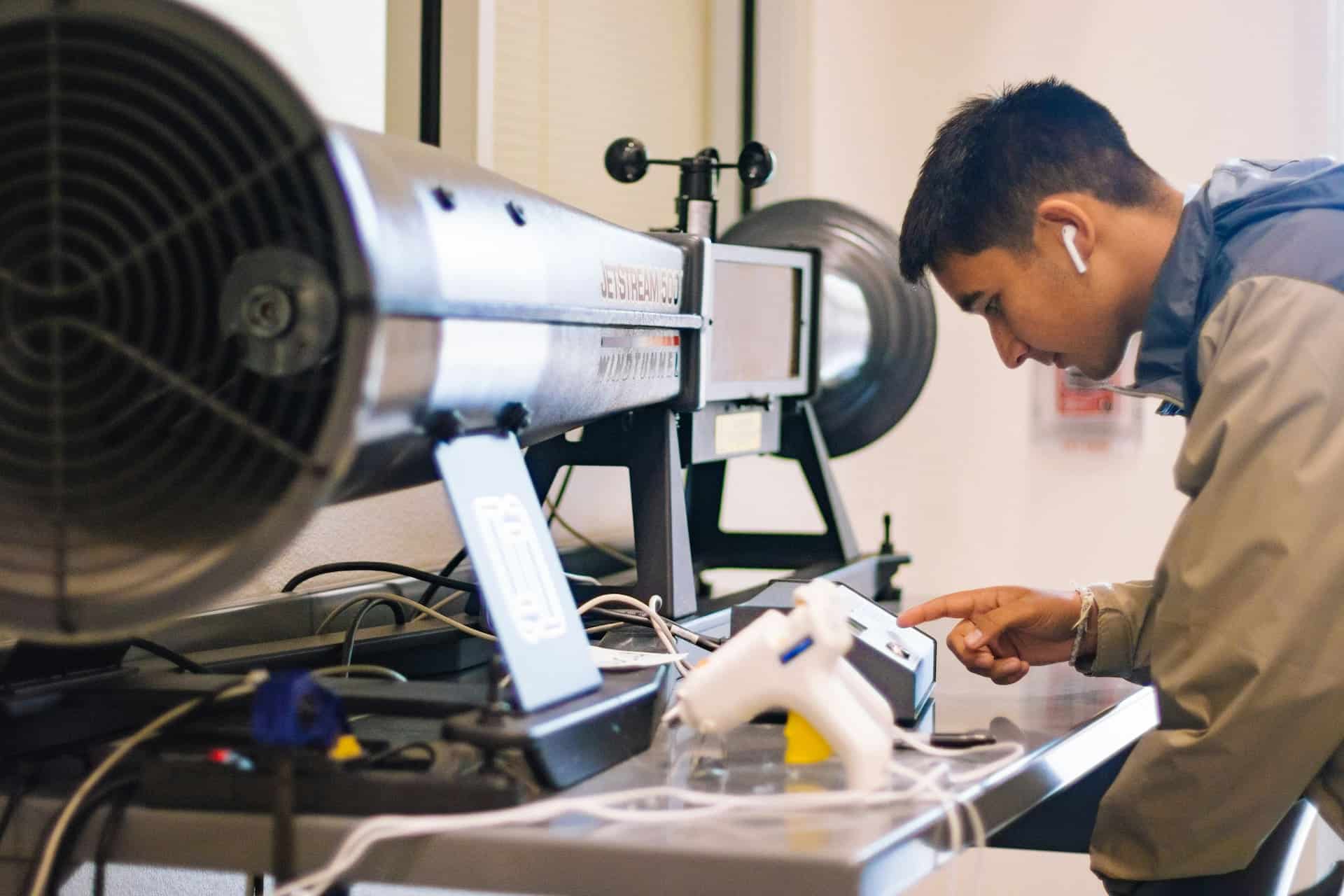Aerospace engineer inspecting jet engine testing equipment in a laboratory environment.