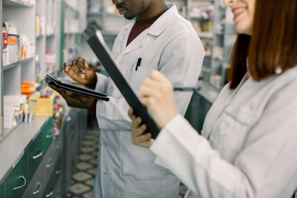 Pharmaceutical professionals reviewing procedures and documentation in a laboratory.