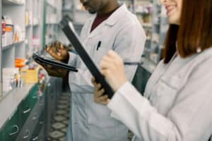 Pharmaceutical professionals reviewing procedures and documentation in a laboratory.